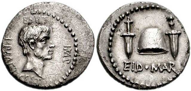 The Ides of March coin, a Denarius portraying Brutus (obverse), minted in 43–42 BC. The reverse shows a pileus between two daggers, with the legend EI