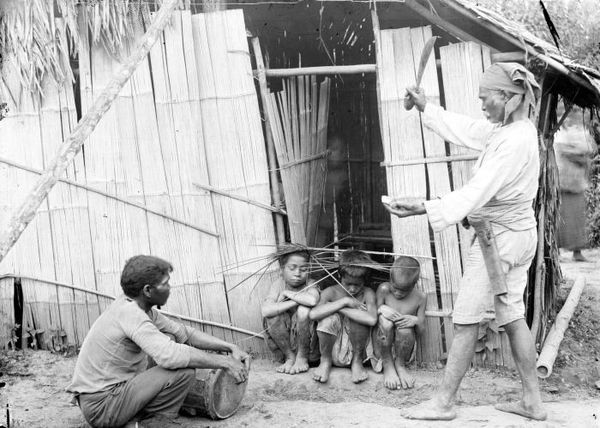 South Moluccan shaman in an exorcism ritual involving children, Buru, Indonesia (1920)