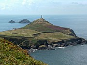 Heinz Monument (the 1864 chimney of the former Cape Cornwall Mine visible in the centre) commemorates the purchase of Cape Cornwall for the nation by H. J. Heinz Company. The ruins of St. Helens Oratory can be seen in the left, with the two offshore rocks called The Brisons in the distance. Cape Cornwall (Judithili) edit.jpg