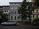 Apartment building with side wing, front garden and enclosure