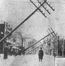 Un uomo si trova in mezzo a una strada mentre le linee dei pali si chinano su di lui.