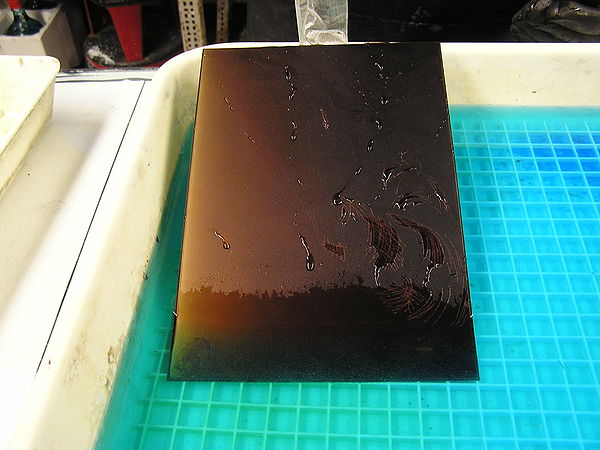 Lowering a copper etching plate into the copper sulfate solution