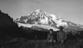 FE Matthes and Edith Matthes sitting in meadow displaying hobnail boots, Mt Rainier, September 1911 (WASTATE 2324).jpeg