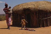 A family outside their hut in Umoja village Famille.jpg