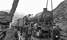 A derailed steam locomotive being lifted back onto the tracks by a rail mounted crane in 1951 Locomotive derailed 2055744.jpg