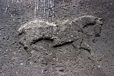 Large low-relief depiction on the interior side of the stone lintel above the entry.