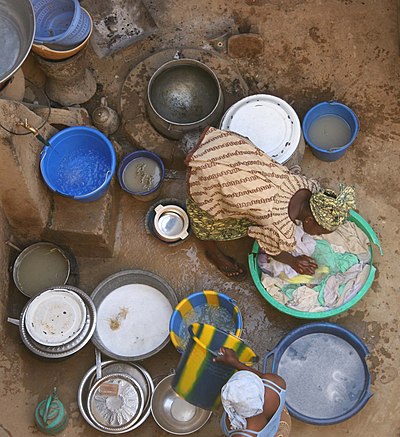 Women washing clothes in Djenné, Mali. Marriage in Mali often includes the acceptance of traditional labour roles, in this case, caring for the home.