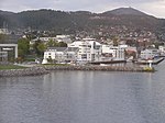 Foto einer an der Küste gelegenen Stadt mit einem Berg im Hintergrund