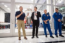 Bridenstine, Elon Musk and NASA astronauts Robert Behnken and Douglas Hurley in front of the Crew Dragon capsule Endeavour as it was being prepared for the Crew Dragon Demo-2 mission (2019) NASA Administrator Visits SpaceX HQ (NHQ201910100019).jpg