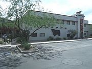 The Tovrea Land and Cattle Co. Administration Building / Stockyards Restaurant was built in 1919 and is located at 5009 E. Washington St. In 1919, Edward A. Tovrea, the “Cattle Baron,” opened his Phoenix packing house west of 48th Street and Van Buren to support his growing beef operations. The Tovrea Land and Cattle Co. had grown to nearly 40,000 head of cattle secured by 200 acres of cattle pens, making it the world’s largest feedlot. In 1947, The Stockyards Restaurant officially opened and quickly became a favorite gathering place for cattlemen, bankers and politicians. Although cattle fortunes faded in the late 1950’s and pens slowly gave way to urban growth, the popularity of Arizona’s Original Steakhouse remained intact.[1]. The property was listed in the Phoenix Historic Property Register in March 2004.