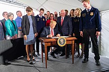 US President Donald Trump signs a 2019 executive order permitting the sale of 15% ethanol fuel year-round President Trump in Iowa (48051796596).jpg