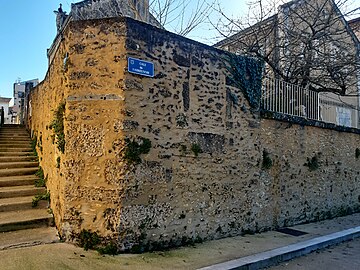 Vestige du rempart à l'angle de la rue Henri Thiébaud et la cale de l'abreuvoir. Le panneau est orné du blason de Mont-de-Marsan.