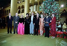 U.S. President Ronald Reagan and First Lady Nancy Reagan with a group at NBC's taping of its "Christmas in Washington" special in the Pension Building in Washington, D.C. Left to right: NBC News anchor Roger Mudd, CBS News reporter Eric Sevareid, Dinah Shore, actress Diahann Carroll, actor and musician John Schneider, President Ronald Reagan, First Lady Nancy Reagan, actor Ben Vereen, and entertainer Debby Boone. Ronald Reagan and group at 1982 Christmas in Washington taping.jpg