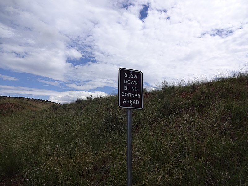 File:Slow down blind corner ahead sign.jpg