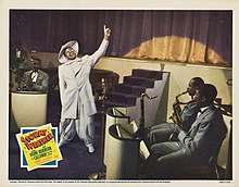 Cab Calloway wears a white zoot suit in a lobby card for the 1943 musical film Stormy Weather. Stormy Weather (1943 lobby card - Calloway & band).jpg