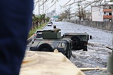 Department of Defense vehicles traveling through a major highway in San Juan flooded with the Hurricane Maria rainfall