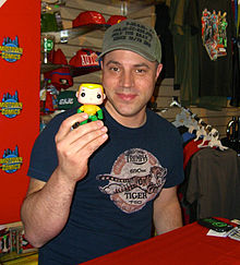Johns holding up a Funko vinyl figure of Aquaman, one of the titles he wrote as part of The New 52 5.11.12GeoffJohnsByLuigiNovi1.jpg