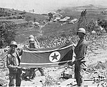 Troops of the US 35th Infantry display a North Korean flag captured along the Nam River