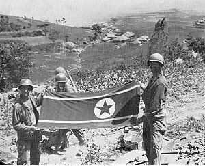 Troops of the US 35th Infantry display a North Korean flag captured along the Nam River. The North Koreans aimed their September offensives at positions in Haman and the Nam River, though limited fighting at Battle Mountain continued Battle Trophy.jpg