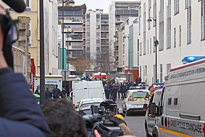 Журналисты, полиция и аварийные службы на улице, на которой произошёл теракт, через несколько часов после нападения. 7 января 2015 года.