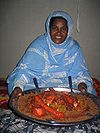 A woman with a plate of camel couscous. Camel Couscous is sure to delight your taste buds!