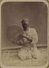 A traditional Central Asian musician from the 1860s or 1870s, holding up his dayereh. Dayra player.jpeg