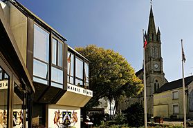 Kleurenfoto van de ingang van het stadhuis met zicht op de kerktoren.