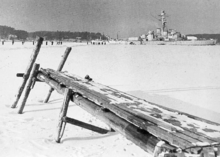 White, frozen sea where dock at the front and the ship at the back.