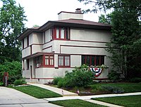 Une maison à deux étages entourée d'arbres