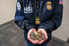 A HSI special agent holds counterfeit championship rings, among $28 million in counterfeit sports memorabilia seized in 2023 IPR Center seizes over $28M in counterfeit sports merchandise ahead of Super Bowl LVIII (8228965).jpg