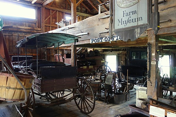 Historical coaches and farming implements in the Hadley Farm Museum