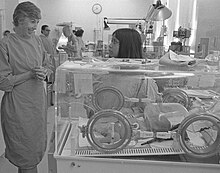 Hodgman, left, speaking with a mother about her 48-hour-old son in incubator, 1976