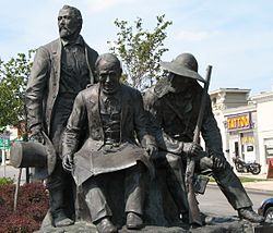 ג'ון קלווין מקוי (במרכז) מונצח יחד עם אלכסנדר מייג'ורס (משמאל) וג'ים ברידג'ר (מימין) בכיכר החלוצים בוסטפורט שבקנזס סיטי. פסל נוסף שלו מוצב בפארק החלוצים שבין שדירת ברודוויי לדרך וסטפורט