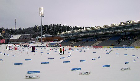 Une piste de ski de fond au premier plan et des tribunes à l'arrière plan.