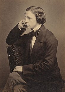 tinted monochrome 3/4-length photo portrait of a seated Lewis Carroll holding a book