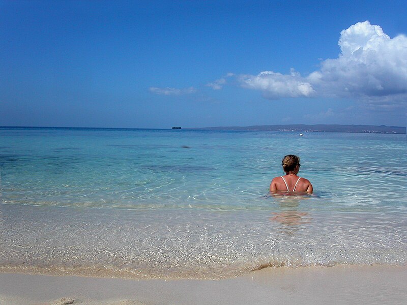 A beachgoer enjoys the morning sun on Lime Cay, off the coast of Kingston, Jamaica. 