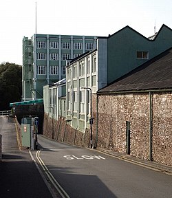 A road leading down a slight incline with buildings on the right