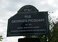 Plaque de rue à Paris, avec l’odonyme simplifié « rue Georges-Picquart ».