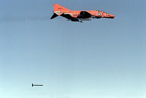 Target tugs, such as this Phantom are often painted in high visibility colors to differentiate themselves from the targets they tow. QF-4B in flight with tow target 1981.JPEG