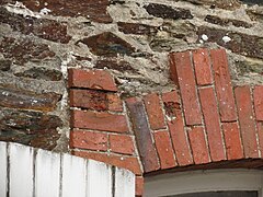 Impacts de balles sur un bâtiment du bourg ayant survécu.