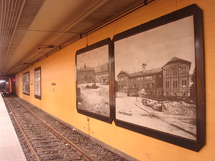 Walls of the underground station decorated with historic photographs, including of the old station building Suedbahnhof Frankfurt tief.JPG