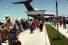 Arrival of UN Visiting Mission, Majuro, 1978. The sign reads "Please release us from the bondage of your trusteeship agreement." TTPI UN Mission 1978.jpg