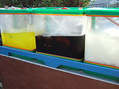 Street vendors selling orange juice, ice cendol, and ice coconut water in hot sunny day