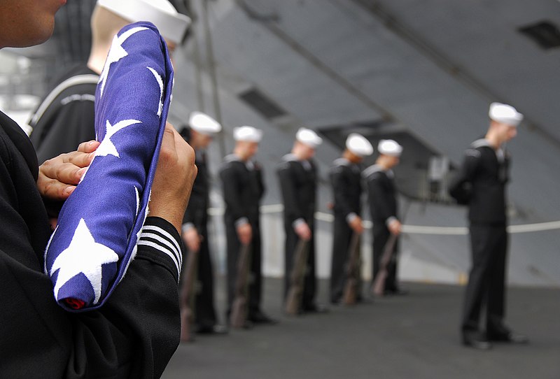 File:US Navy 090216-N-6597H-104 Religious Program Specialist Pablo Monroy, from Pasco, Wash., holds an American flag during a burial-at-sea service on aircraft elevator four aboard the Nimitz-class aircraft carrier USS John C. Stenn.jpg