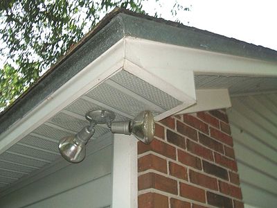 Boxed in soffit on a house in Northern Florida, United States. In this example the soffit material is 12 inches wide and made from center lanced U groove perforated sections of vinyl in a return fashion and fixed to the bottom chord of a truss roofing system extending beyond the exterior wall