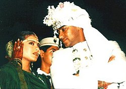 Ajay Devgn mengenakan sebuah jas berwarna putih, dan Kajol mengenakan sebuah sari gaya Maharashtra berwarna hijau