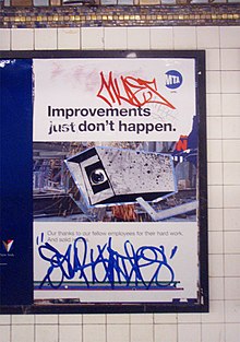 defaced MTA poster with graffiti showing a CCTV camera where the lens is an eye