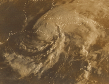 Black and white satellite image of a weakening tropical storm. The white represents clouds and the lines are country and state borders while the black represents land and water. The Gulf of Mexico is at the bottom of the image, with the spiraling hurricane situated over Louisiana. Most of the southern and central United States can be seen in the image.
