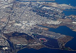 Aerial view of the Bayview-Hunters Point and India Basin neighborhoods of San Francisco from 2007. The view is oriented approximately north. Prominent features include Candlestick Park (prior to its demolition) at the bottom of the image, and Third Street, seen prominently cutting diagonally across the left third of the photograph, from the lower part of the left edge to the upper edge.
