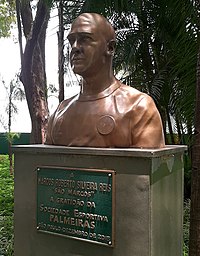 Um busto de bronze, representando um homem. No pedestal, está escrito "A MARCOS ROBERTO SILVEIRA REIS - "São Marcos" - a gratidão da Sociedade Esportiva Palmeiras. São Paulo, dezembro de 2015"